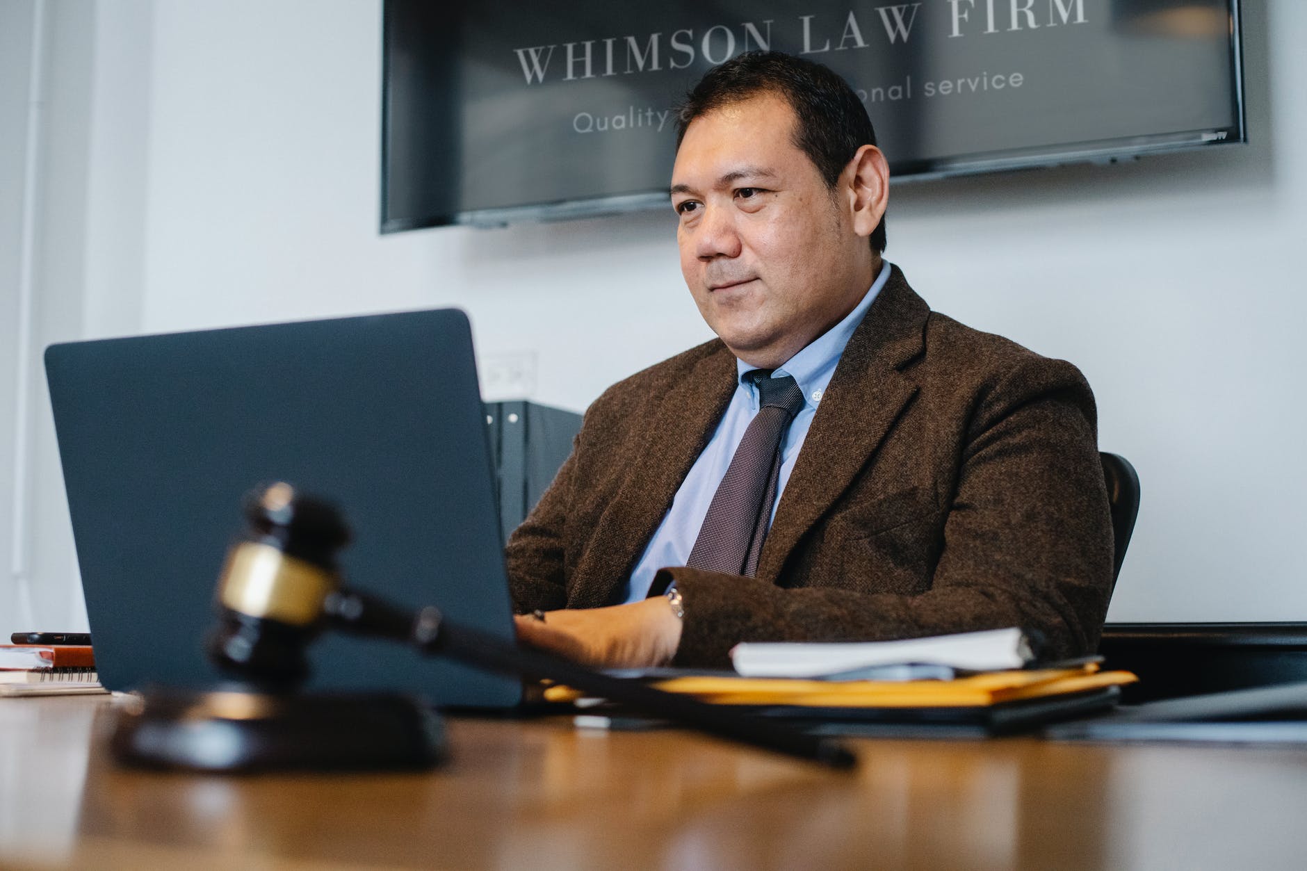 positive asian lawyer using laptop in modern office